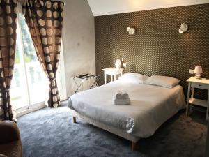 ein Schlafzimmer mit einem Bett mit zwei Handtüchern darauf in der Unterkunft Hôtel Restaurant Logis Coté Lac in Savenay
