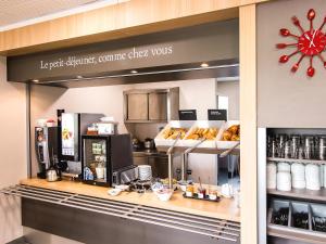 a coffee shop with a counter with food on it at B&B HOTEL Royan La Palmyre in Vaux-sur-Mer