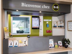 sklep z kuchenką mikrofalową z napisem na ścianie w obiekcie B&B HOTEL Royan La Palmyre w mieście Vaux-sur-Mer