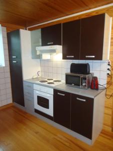 a kitchen with a stove and a microwave at Domaine de la Pinsonnière in La Livinière