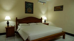 a bedroom with a bed and two lamps on tables at Swastika Bungalows in Sanur +71 photos