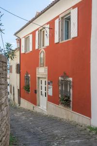 un bâtiment rouge et blanc dans une rue dans l'établissement Guesthouse Villa Marija, à Motovun