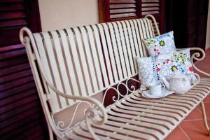 a white bench with pillows and cups on it at Il Giardino di Matilde in Perugia