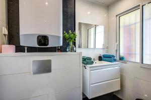 a white kitchen with a sink and a mirror at WIlson Palace - Studio avec terrasse et climatisation in Antibes