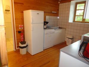 a kitchen with a white refrigerator in a room at Domaine de la Pinsonnière in La Livinière
