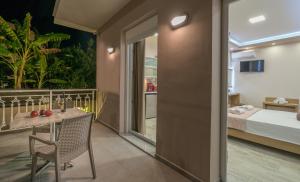 a room with a table and chairs and a bed at Nikos & Maria Studios in Laganas