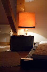 una lámpara sentada junto a una cama con una maleta en Apartmani Memory, en Višegrad