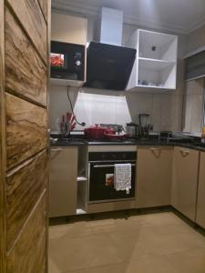 a small kitchen with a stove and a microwave at Esthelixapartment in Madina