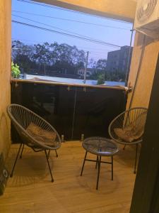 a balcony with two chairs and a large window at Esthelixapartment in Madina