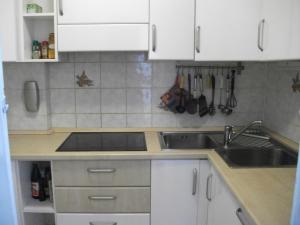 a kitchen with white cabinets and a sink at Cervinia Apartments in Breuil-Cervinia