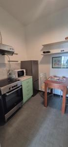 a kitchen with a stove and a table in it at Eremare Marinella in Marinella di Sarzana