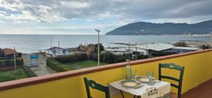 a table and chairs on a balcony with a view of the ocean at Eremare Marinella in Marinella di Sarzana