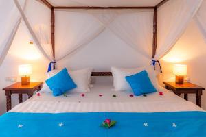 a bedroom with a bed with blue and white pillows at Empiris Lodge in Sekenani