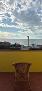 a bench against a yellow wall with a view of the ocean at Eremare Marinella in Marinella di Sarzana +3 photos