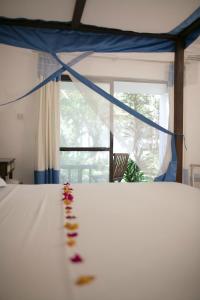 a group of flowers on a bed with a window at Empiris Lodge in Sekenani