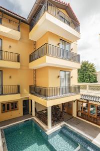 an apartment building with a swimming pool and balconies at Lumi Hội An Hotel in Hoi An