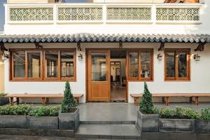 a house with a wooden door and benches at Lumi Hội An Hotel in Hoi An +154 photos