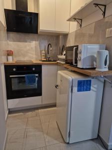 a kitchen with a white refrigerator and a stove at Różowe sny in Kłodzko