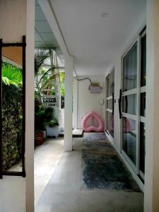 a hallway with a pink chair in a building at Tripo Dhiffushi Villa in Dhiffushi