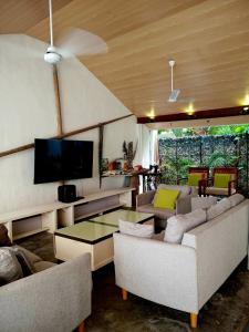 a living room with couches and a flat screen tv at Tripo Dhiffushi Villa in Dhiffushi