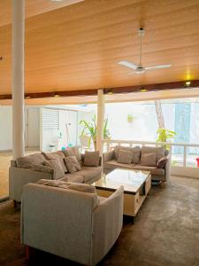 a living room with a couch and a table at Tripo Dhiffushi Villa in Dhiffushi +50 photos