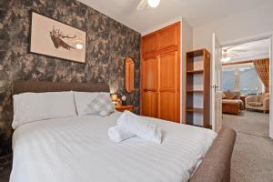 a bedroom with a white bed and a living room at Ramsay Lane in Lossiemouth +14 photos