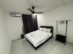 a bedroom with a bed with a ceiling fan at KH Homestay in Kampong Batu Lapan