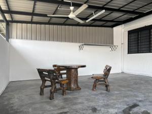 a table and two chairs in a room at KH Homestay in Kampong Batu Lapan