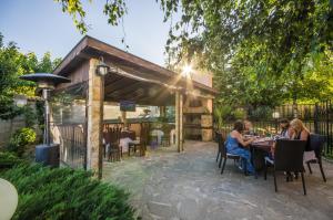 un groupe de personnes assises à une table sur un patio dans l'établissement Guest House La Casa, à Varna