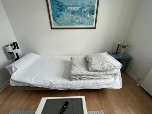 a bedroom with a bed with white sheets and a table at Cozy base near the cathedral in Viborg