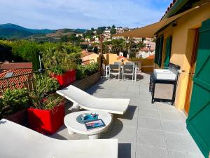 a balcony with a table and a toilet on a building at Le Rooftop Collioure in Collioure