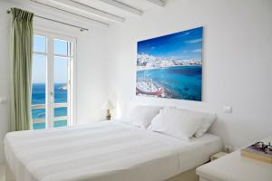 Un dormitorio blanco con una cama grande y una ventana en Elia White Residence, en Playa de Elia