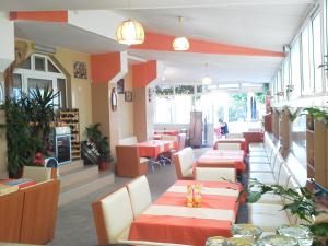ein Restaurant mit roten und weißen Tischen und Stühlen in der Unterkunft Krasi Hotel in Rawda