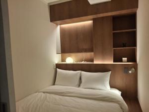 a bedroom with a bed with a wooden headboard at StayShim in Seoul