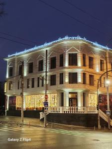 a white building with christmas lights on it at London Boutique Hotel in Chişinău
