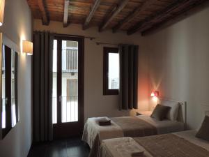 1 dormitorio con 2 camas y ventana en Casa Rural Vistes de Morella, en Morella