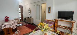 a living room with a flat screen tv and a table at AVRA House in Karfas