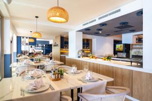 a restaurant with tables and chairs and a bar at Poseidon The Beach Hotel in Budva