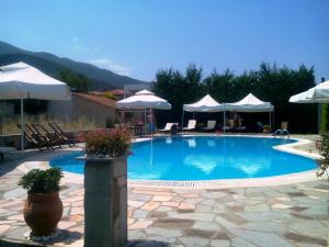 a large swimming pool with chairs and umbrellas at Villa Riviera in Stavros