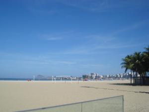 una red de voleibol en una playa de arena con palmeras en Ótima Opção Em Copacabana, en Río de Janeiro