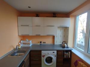 a kitchen with a sink and a washing machine at Airport 24h in Chişinău