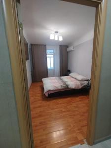 a bedroom with a bed and a wooden floor at Airport 24h in Chişinău