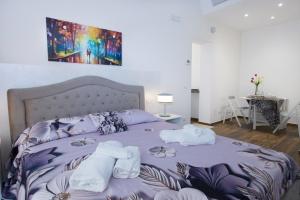 a bedroom with a purple bed with towels on it at Premiere Luxury Catania in Catania