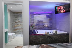 a bathroom with a tub with a tv on the wall at Premiere Luxury Catania in Catania +61 photos
