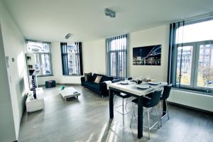 een woonkamer met een tafel en een bank bij Les Suites de Nanesse in Luik