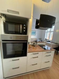 a kitchen with a microwave and a stove at Cozy base near the cathedral in Viborg