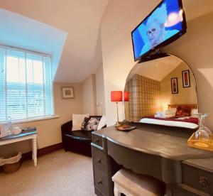 a room with a bed and a tv on the wall at 3 Cambridge Villas in Ambleside