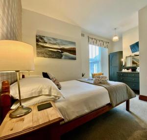 a bedroom with a bed with a lamp on a table at 3 Cambridge Villas in Ambleside