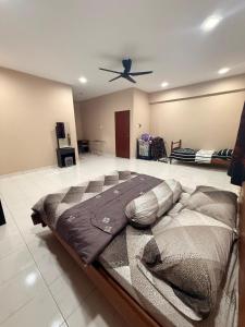 a large bed in a room with a ceiling fan at De'Lunar Homestay in Johor Bahru