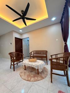 a living room with three chairs and a ceiling fan at De'Lunar Homestay in Johor Bahru